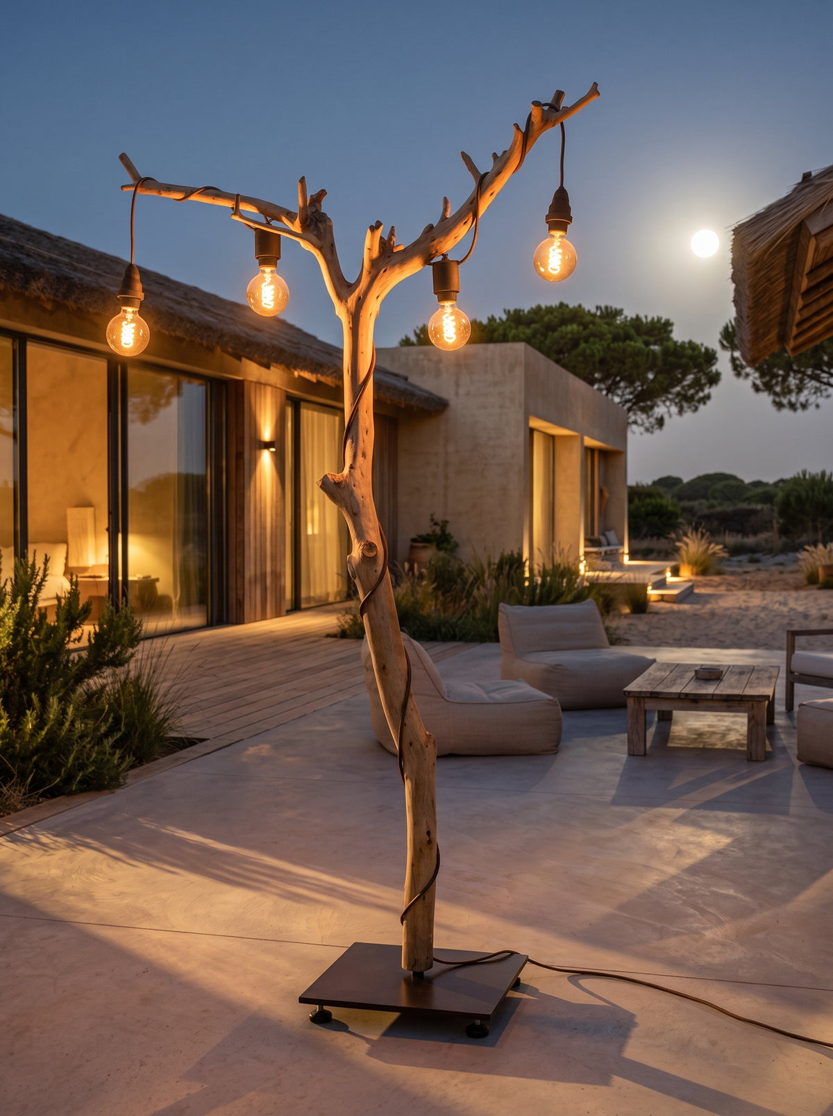Candeeiro de pé ALCE em tronco de oliveira aceso ao anoitecer, num terraço de uma casa com lua cheia ao fundo | LAMS Woodcrafts