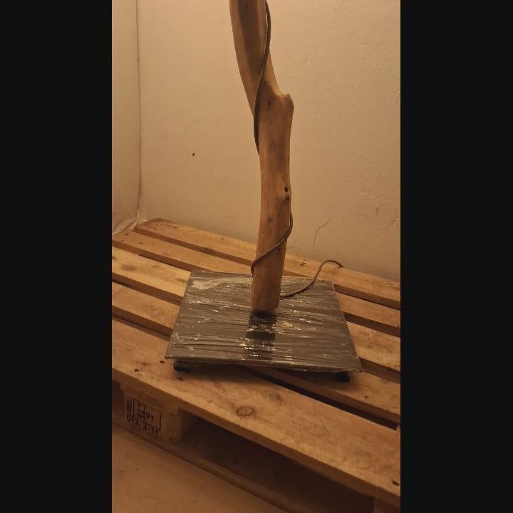 Vídeo do candeeiro de pé ALCE: base metálica preta e tronco de oliveira com o cabo enrolado, sobre um palete | LAMS Woodcrafts